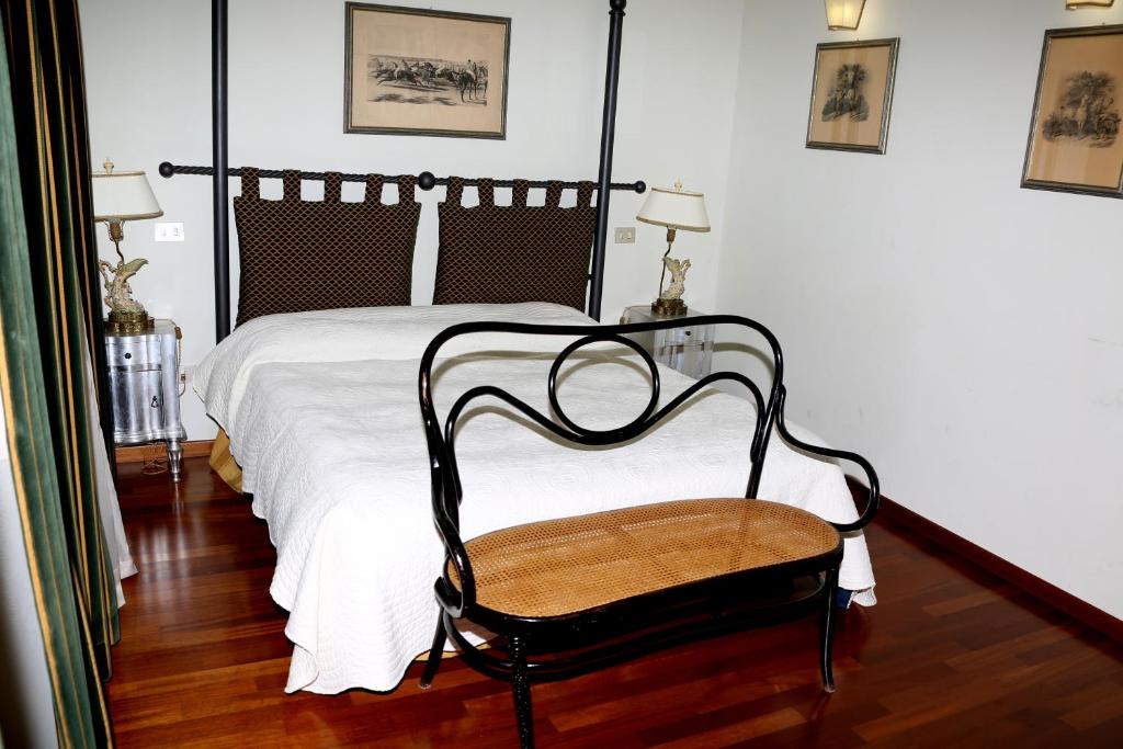 a bedroom with a black and white bed and a chair at Locanda Guidi in Sansepolcro