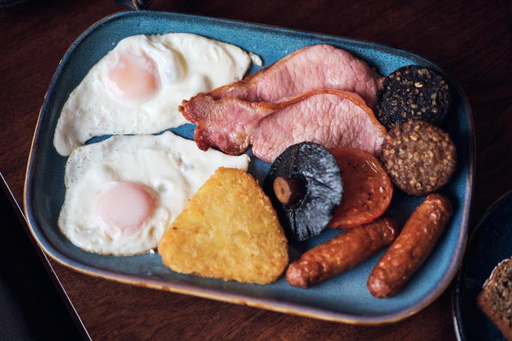 a blue plate of food with eggs sausage and meat at Murphy's Pub and Bed & Breakfast in Dingle
