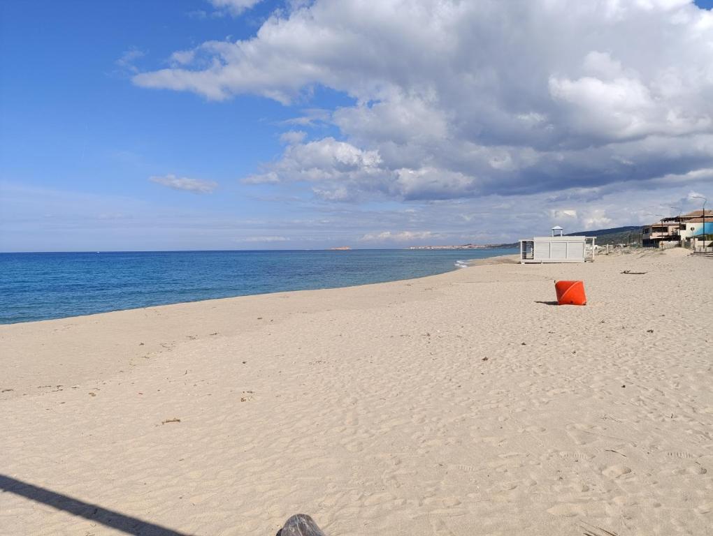 a beach with an orange object on the sand at En Allusi Apartment in Badesi