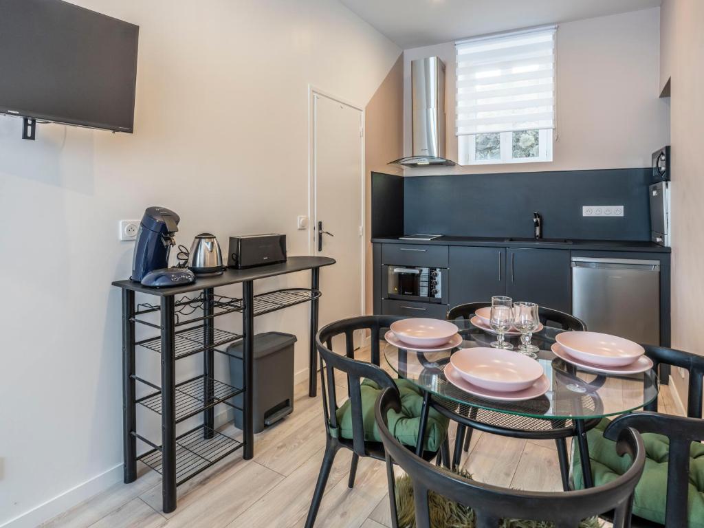 a dining room with a table and chairs in a kitchen at Studio centre ville La Bourboule in La Bourboule