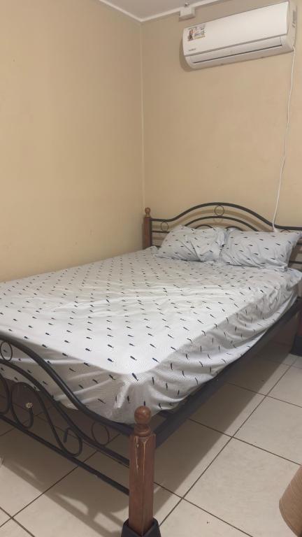 an empty bed in a room with a fan at the hideaway in Christ Church