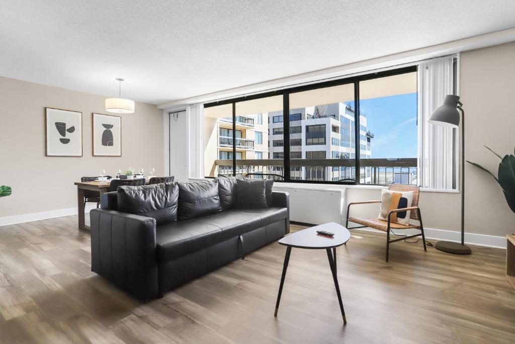 a living room with a black couch and a table at Stylish Apt in Crystal City in Arlington