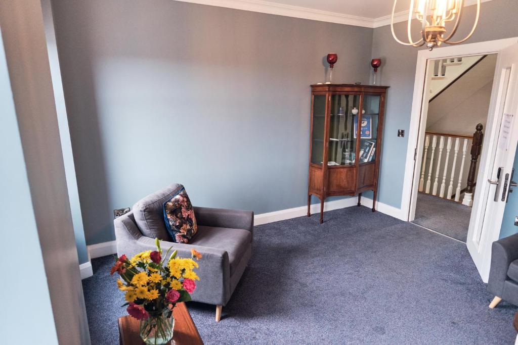 a living room with a couch and a table with flowers at Murphy's Pub and Bed & Breakfast in Dingle