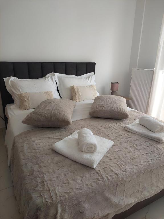 a large white bed with towels on top of it at Ammos Family Villa in Daratso