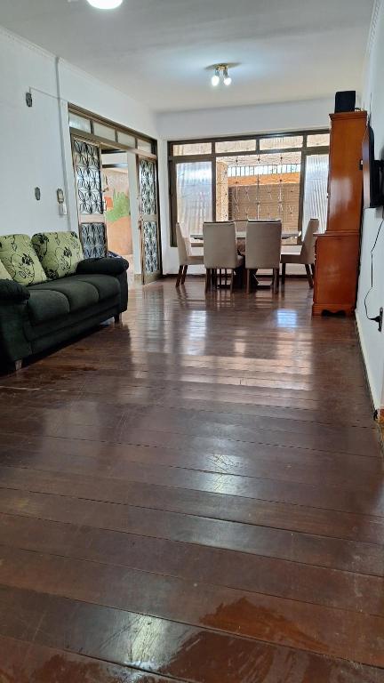 a living room with a couch and a table and chairs at Casa Completa até 20 pessoas in Ribeirão Preto