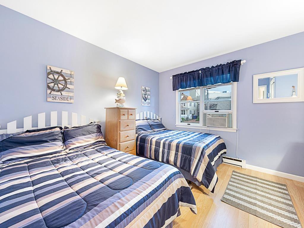 2 Betten in einem Schlafzimmer mit blauen Wänden in der Unterkunft Wifi, Ourdoor Shower, Porch Ocean Side 1St Floor Duplex, A Short Walk From The Best Lbi Attractions, A Small Park, And The Beach, in Beach Haven