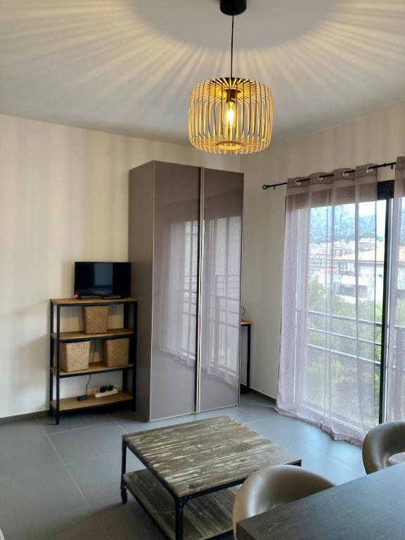 un salon avec une table et un lustre dans l'établissement Marina d'Oru Studio Propriano, à Propriano