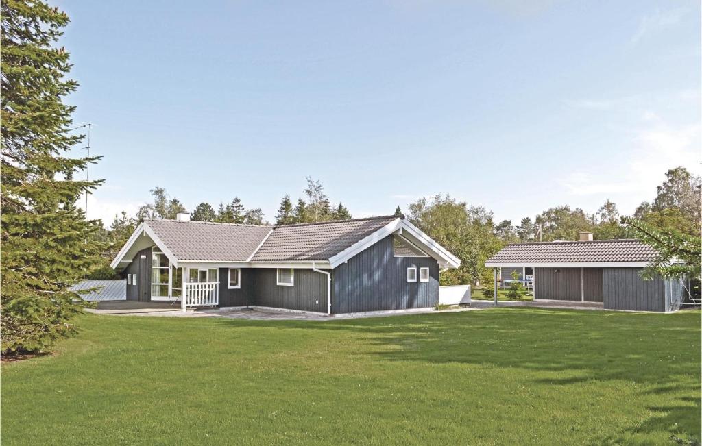 una casa con una casa negra y un patio en Holiday Home Mimosevej Væggerløse Vi, en Bøtø By