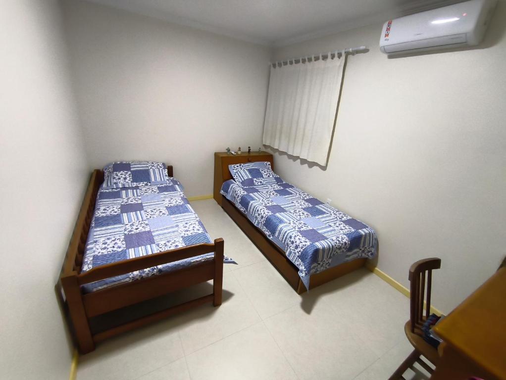 a bedroom with two beds and a window in it at Quarto em Caruaru para o São João in Caruaru