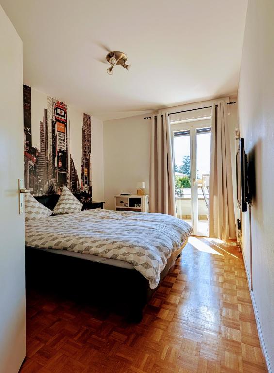 a bedroom with a bed and a large window at Locarno, Casa Pioda - nahe Zentrum, mit Balkon und Parkplatz in Locarno