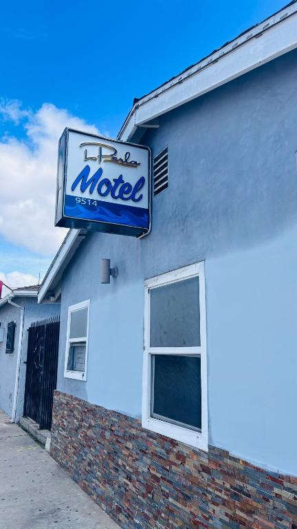 a motel sign on the side of a building at La Perla motel in South Gate