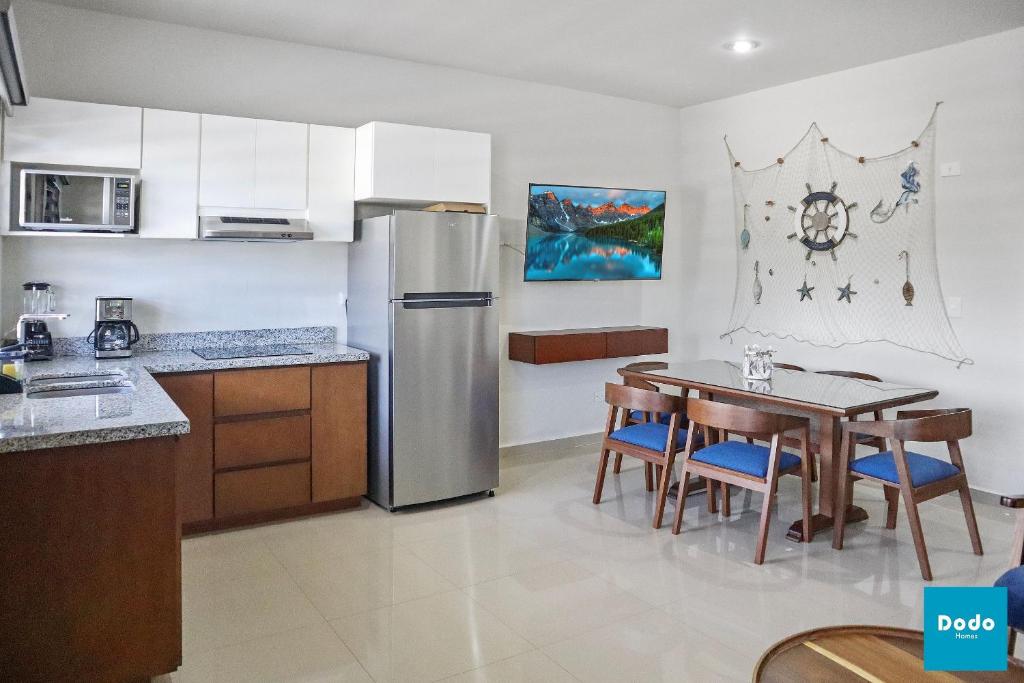 a kitchen with a table and a stainless steel refrigerator at Residencial a 5 min. de plaza comercial in Mazatlán
