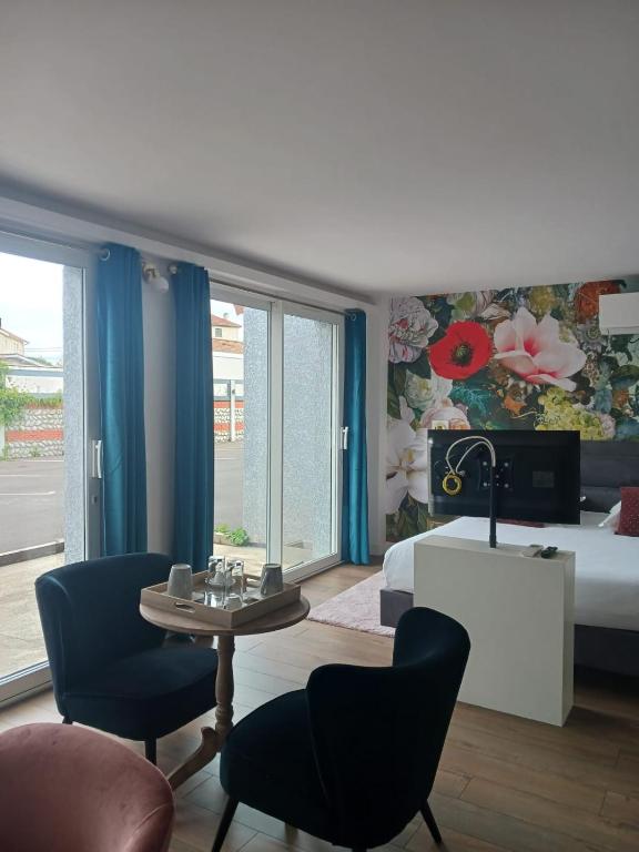 une chambre d'hôtel avec un lit, une table et des chaises dans l'établissement Touraco, à Villars-les-Dombes