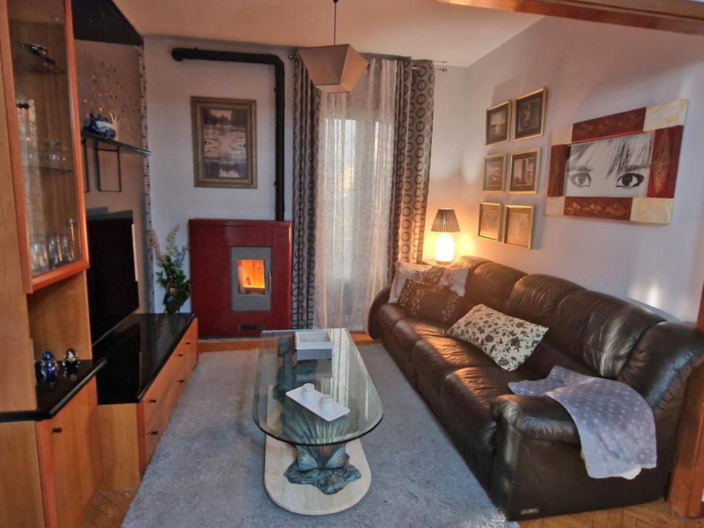 a living room with a leather couch and a glass table at Piso vacacional en Casa Carroucha in Valga