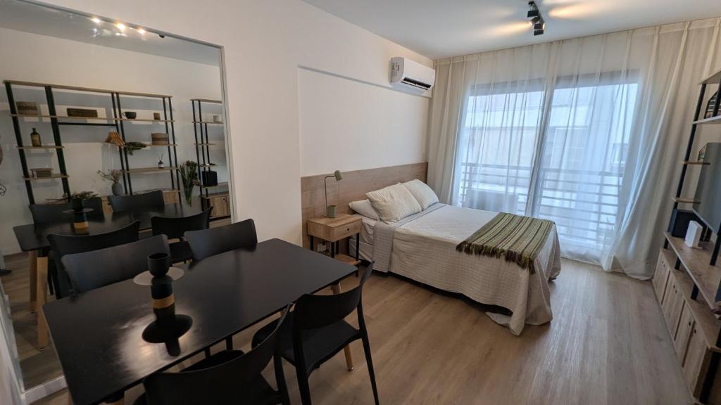 a bedroom with a bed and a table and chairs at Monoambiente Nuevo en Belgrano in Buenos Aires