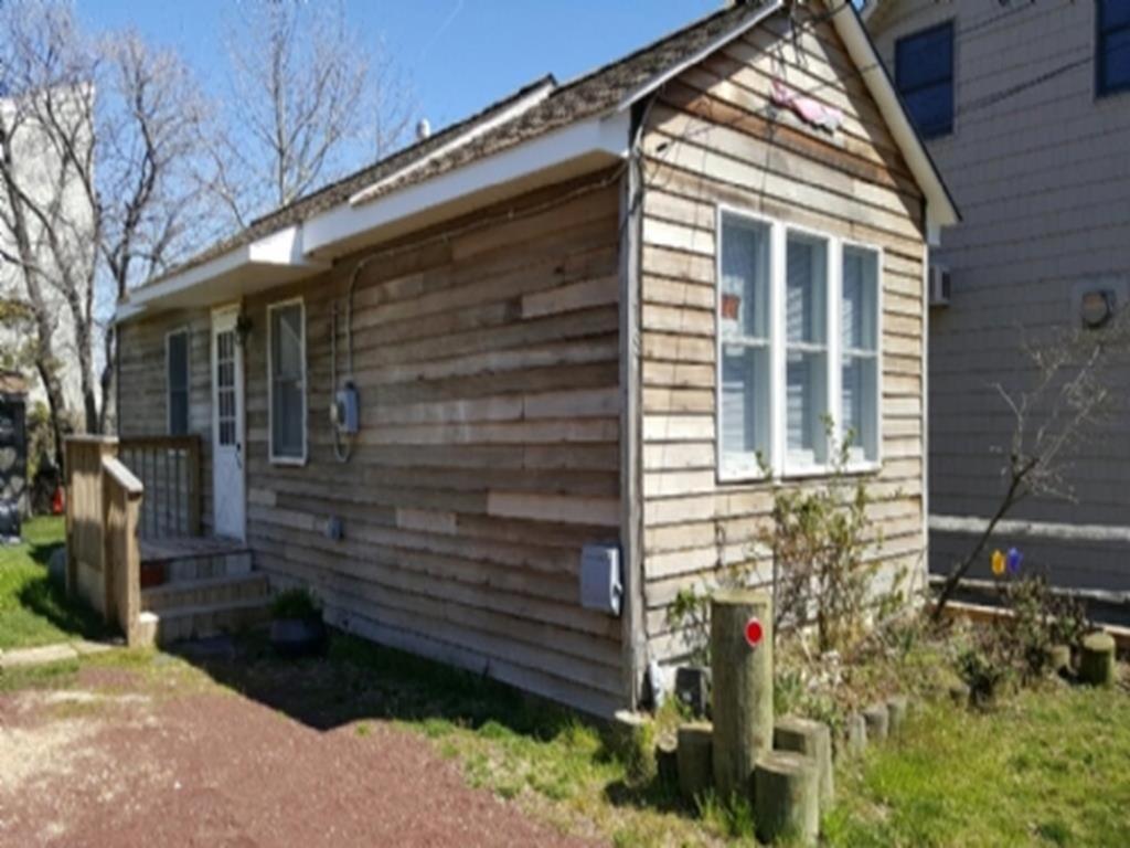 ein kleines Holzhaus mit einem Fenster an der Seite in der Unterkunft Ocean Block Beach Badges Cute Cottage In The Oceanblock No Streets To Cross 7 Houses To The Ocean Rear Cottage 13048 in Surf City