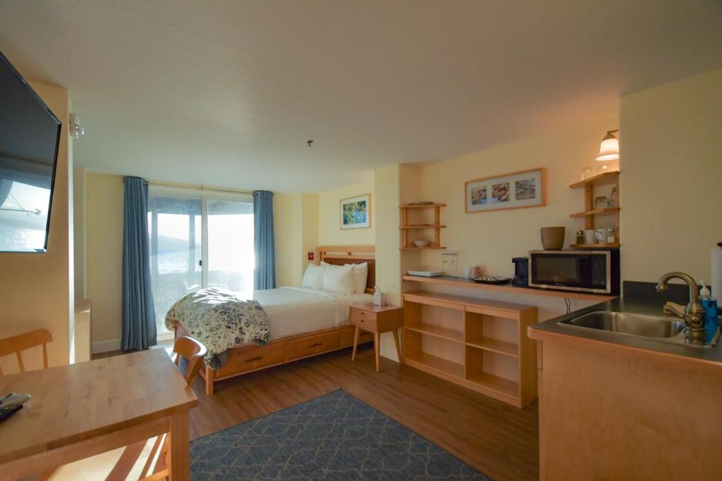 a bedroom with a bed and a kitchen with a sink at Lakeshore Lodging Lodge 613 in Homer