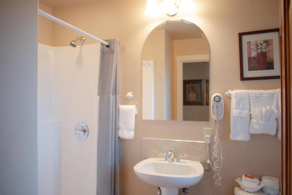 a bathroom with a sink and a shower with a mirror at Lakeshore Lodging Lodge 709 in Homer