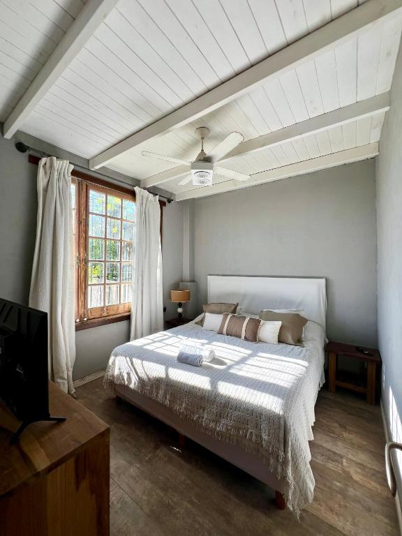 a bedroom with a bed and a ceiling fan at La Pulperia in Capilla del Señor