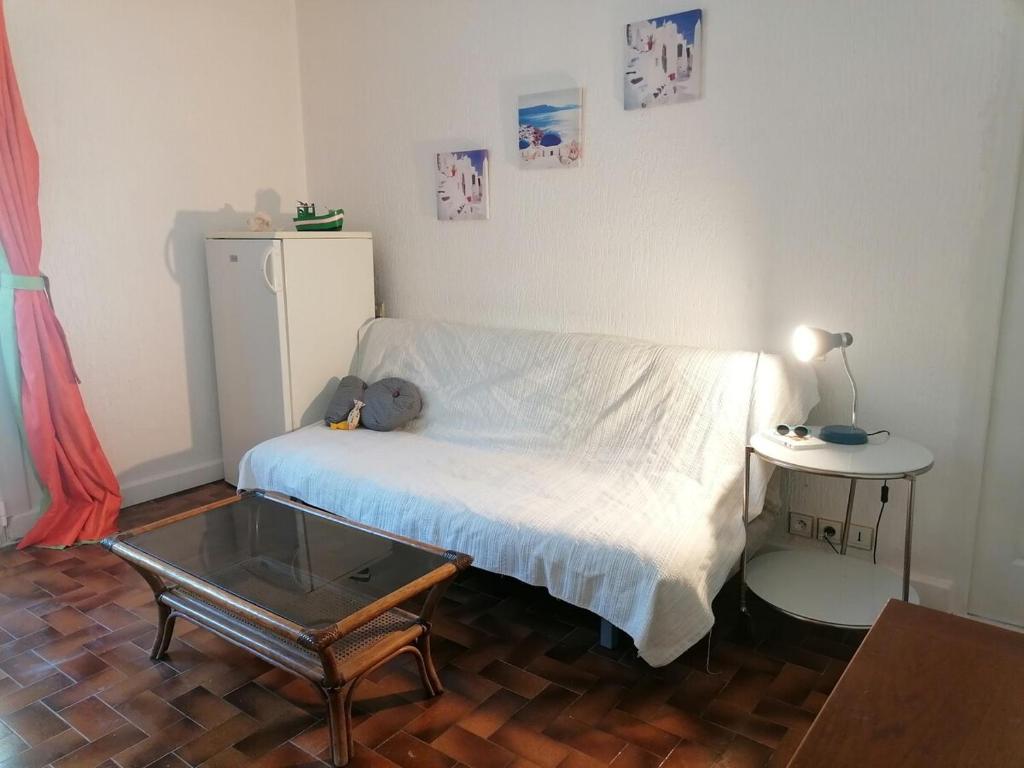 una piccola stanza con un letto e un tavolo di Gîte les iris Laroque 34 DOUBLON a Laroque