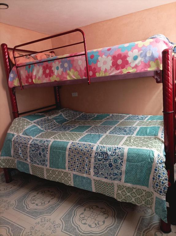 a bedroom with a bunk bed with a quilt at La Casa de los Abuelos in Zacatlán