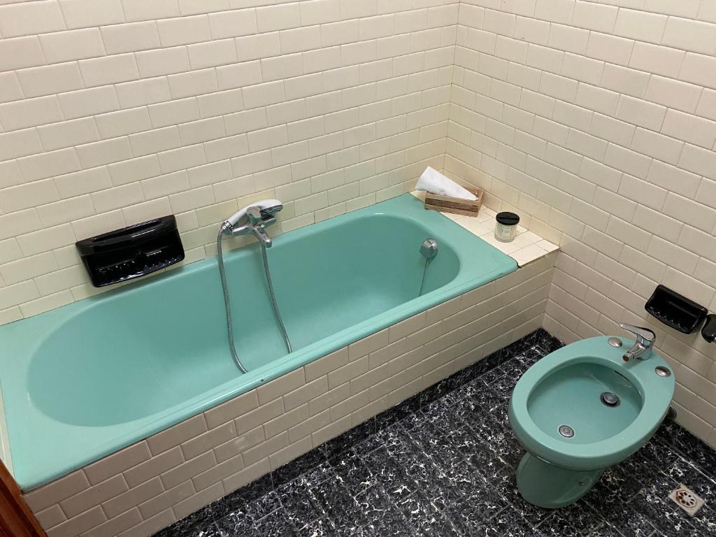 a bathroom with a blue tub and a toilet at La Dimora della Maestra in Vita