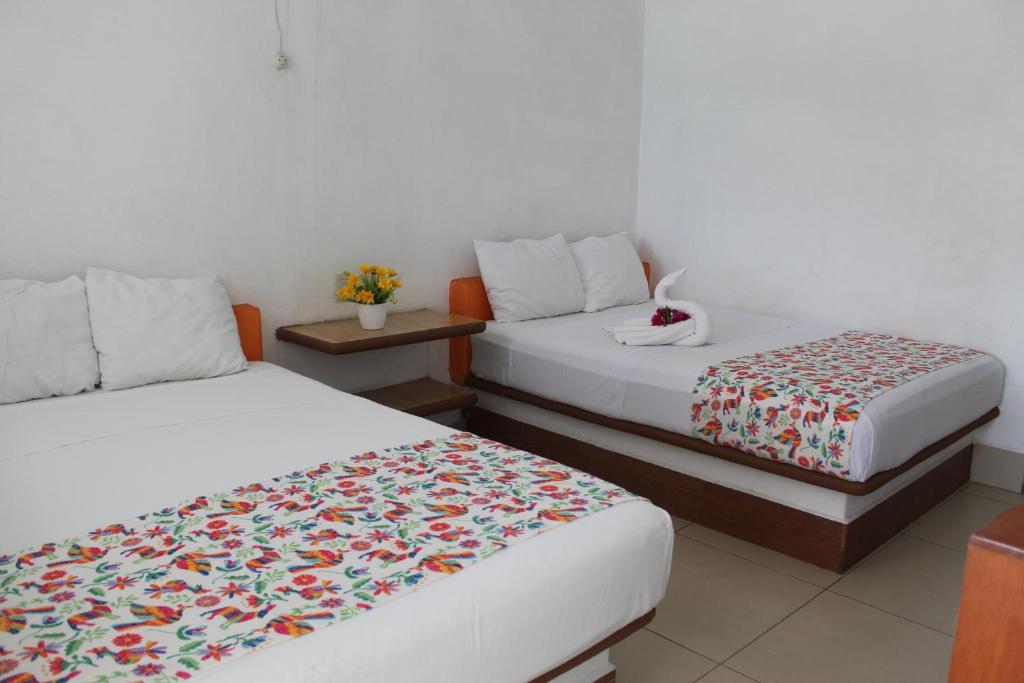 Ένα ή περισσότερα κρεβάτια σε δωμάτιο στο Hotel Victoria Zihuatanejo