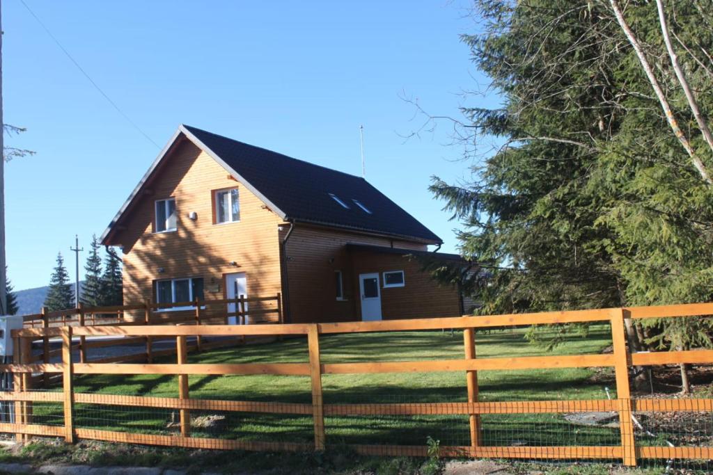une maison avec une clôture devant dans l'établissement Vanilla Mountain Resort, à Bălceşti