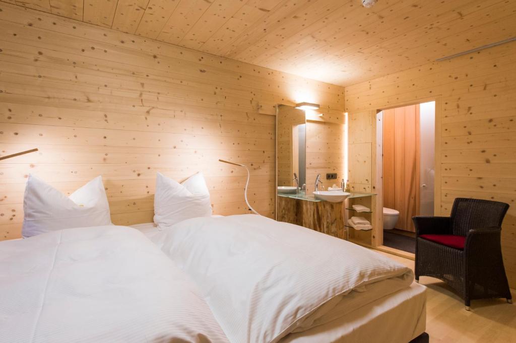 a bedroom with a large white bed with a wooden wall at Sleepwood Hotel in Eupen