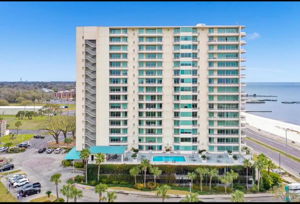 a large white building with a parking lot and the ocean at Ocean Club 1206 Premier in Biloxi