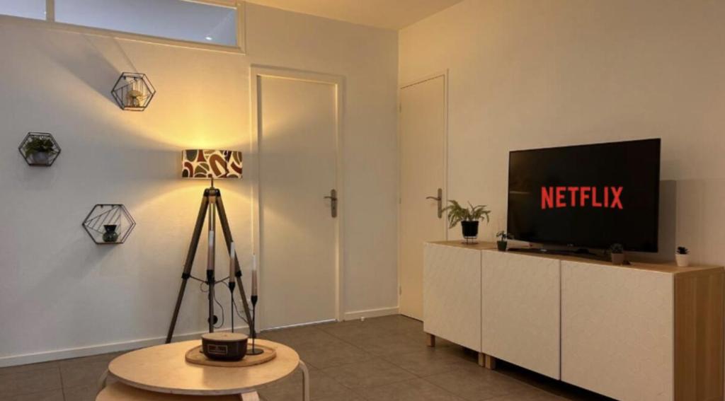 un salon avec une télévision et une table dans l'établissement Le St Antoine Central - Gare, à Mâcon