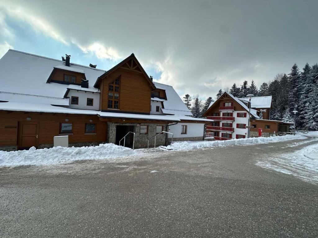 a building with snow on the side of a road at BOLFI LUX Apartma z balkonom in Pohorje