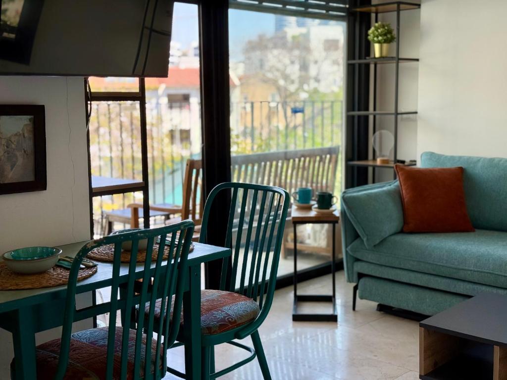a living room with a table and chairs and a couch at Lovely 1-bedroom apartment in The best location in Tel Aviv