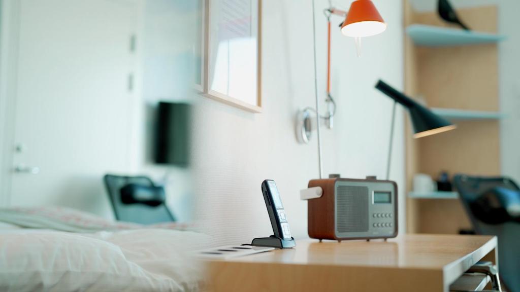 a room with a bed and a small computer on a desk at Hotel Arctic in Ilulissat