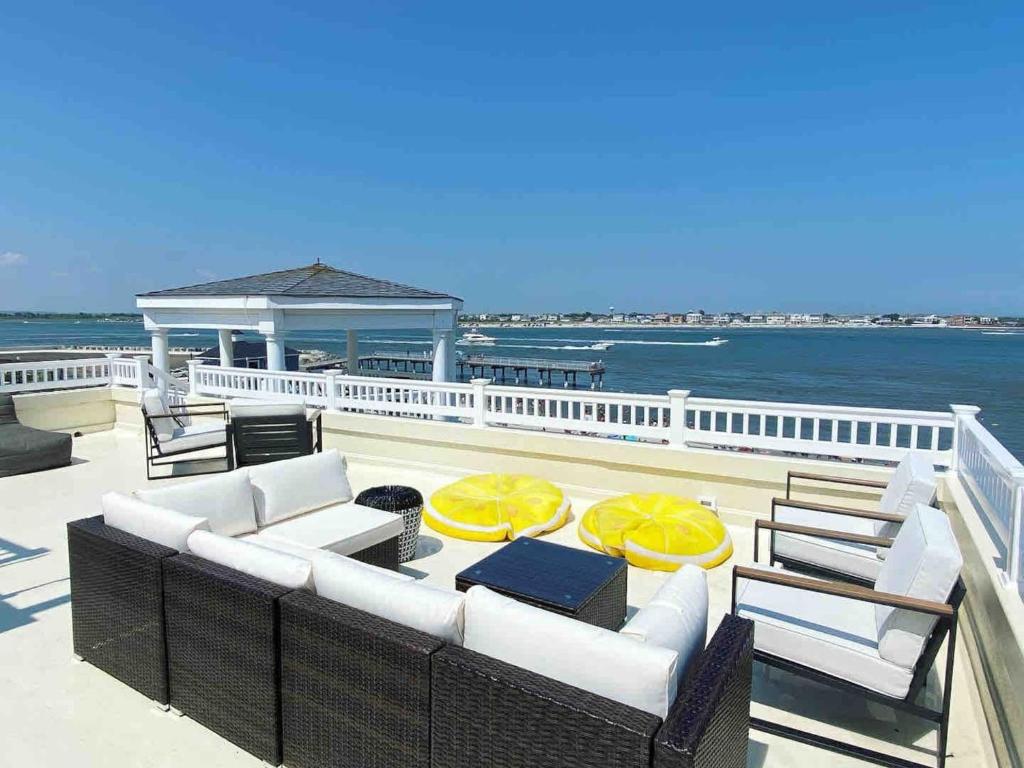 a patio with white chairs and tables and the ocean at Icon Playce: Beachfront with 360 rooftop in Atlantic City