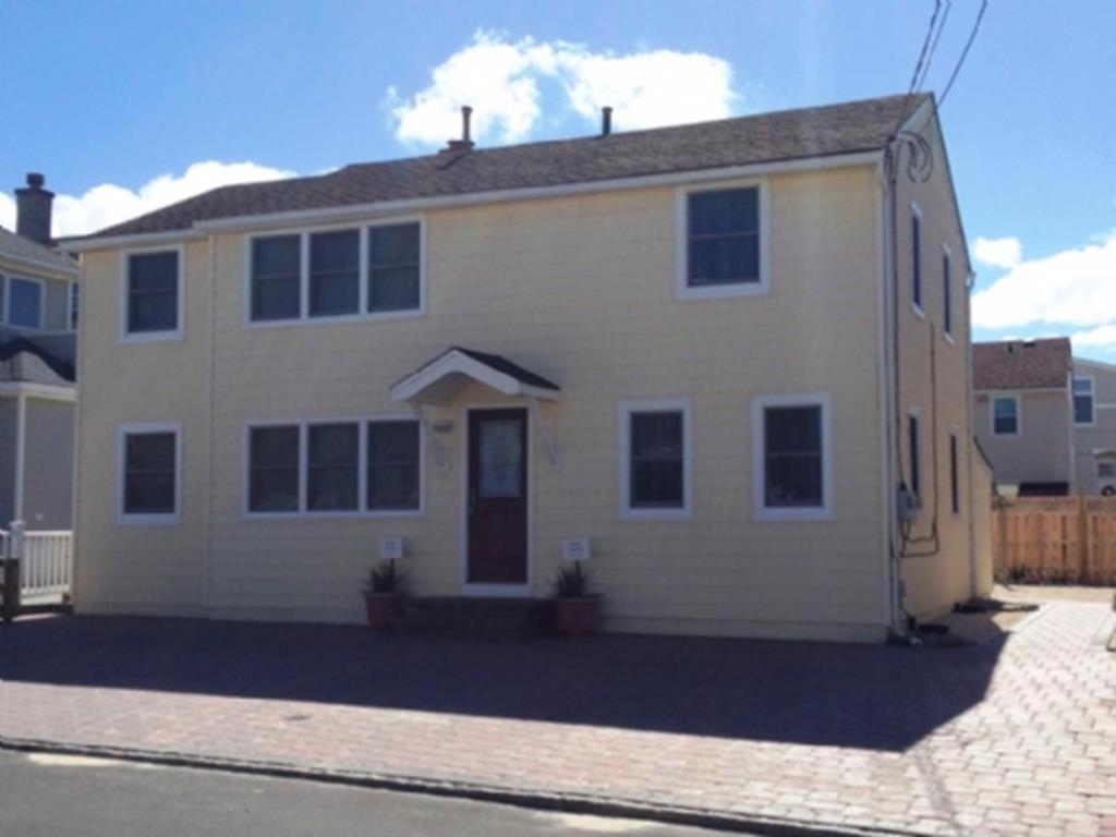 una gran casa blanca en una calle de ladrillo en Ocean Block Internetwifi Deck Washer & Dryer Well-Maintained First Floor Unit Of An Ocean Block Duplex Great Location, Just One House Between, en Peahala Park