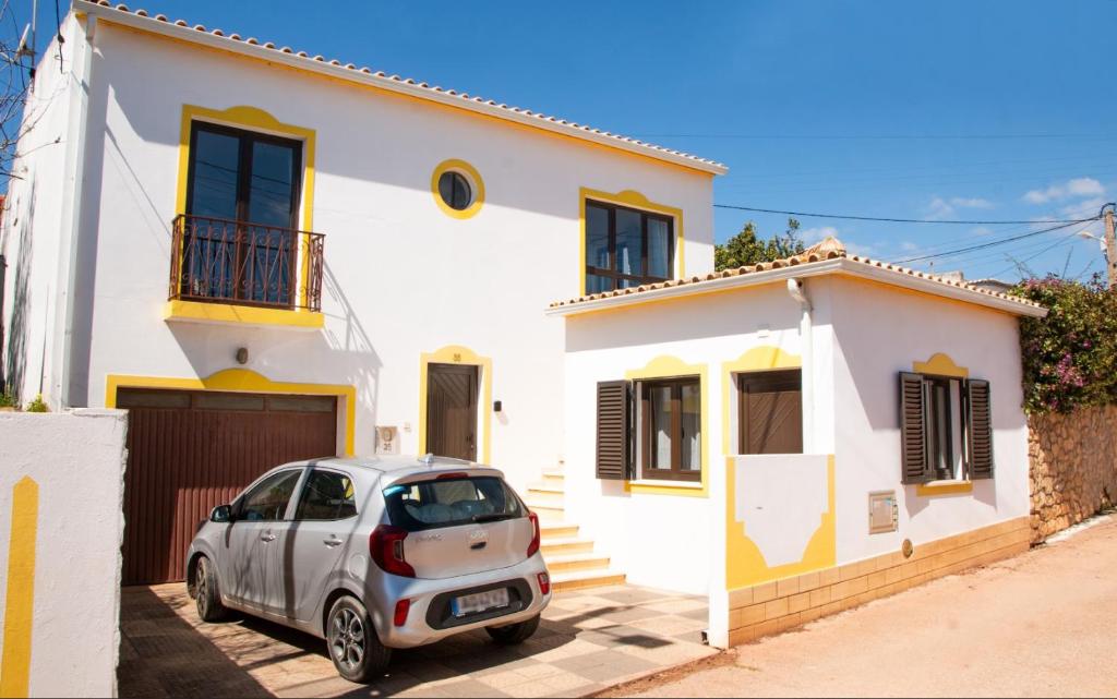 a car parked in front of a white house at Casa Bellarosa in Raposeira