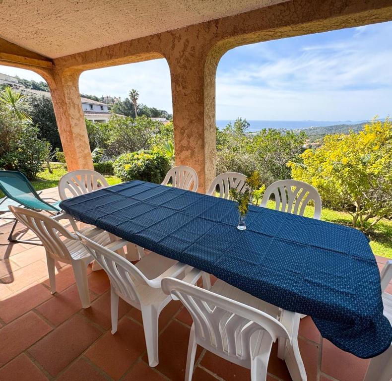 - une table bleue et des chaises blanches sur la terrasse dans l'établissement Domaine Mare e Monti - T2 Les Mimosas, à Albitreccia
