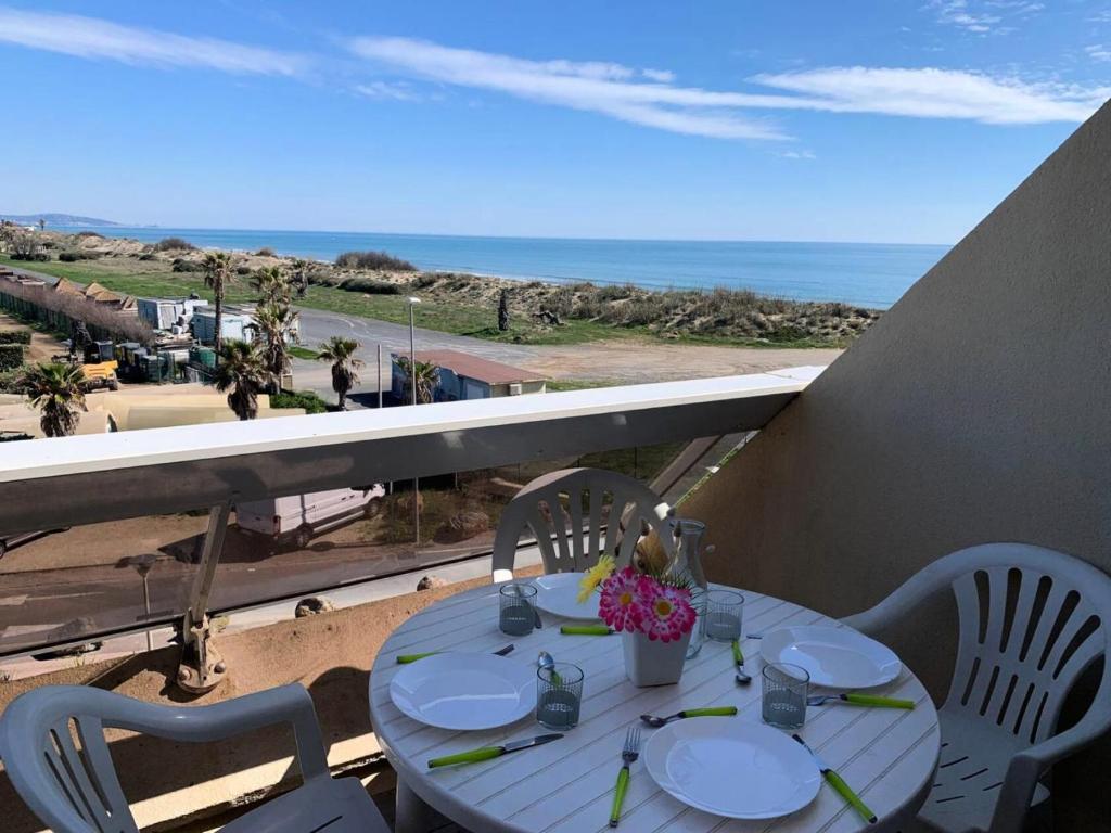 - une table sur un balcon avec vue sur l'océan dans l'établissement Résidence Héliopolis Bâtiment Ab - Studio Cabine 2 pers- Héliopolis Bât. AB MAE-7211, au Cap d'Agde