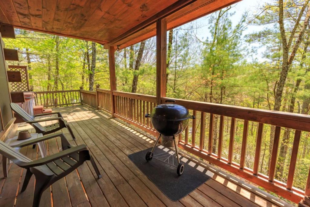 a screened in porch with a grill on it at Dancing Bear - Cherry Log GA - Dog Friendly Cabin - Mountain Views, Hot Tub, Wood-Burning Fireplace - 15 Minutes to Downtown Blu in Blue Ridge