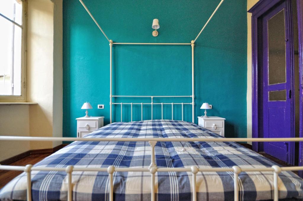 - une chambre dotée d'un lit avec un mur bleu dans l'établissement La Boqueria, à Bra