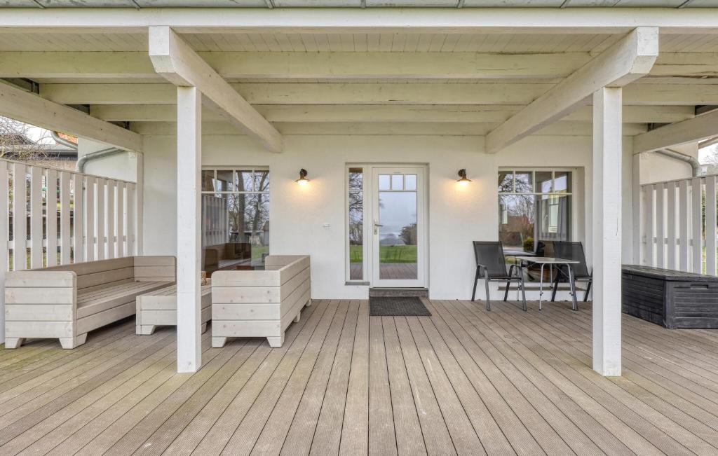 a porch with white furniture and a table and chairs at Seehaus Apartment in Klein Upahl