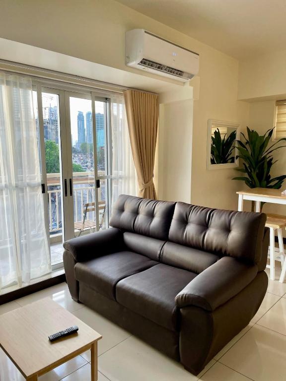 un divano in pelle nera in un soggiorno con di 5 Star Luxury Condo - Metro Manila a Manila
