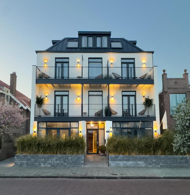 een wit huis met een zwart dak bij Boutique Hotel At Sea in Zandvoort