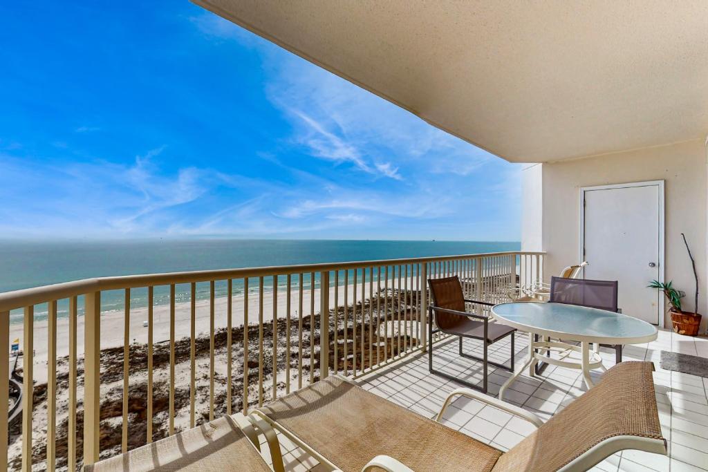 a balcony with a table and chairs and the ocean at The Beach Club 1102B in Gulf Highlands