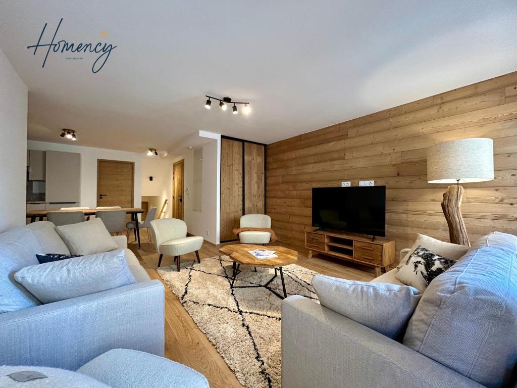 un salon avec deux canapés et une télévision dans l'établissement Homency - Résidence L'Expression D02, à L'Alpe-d'Huez