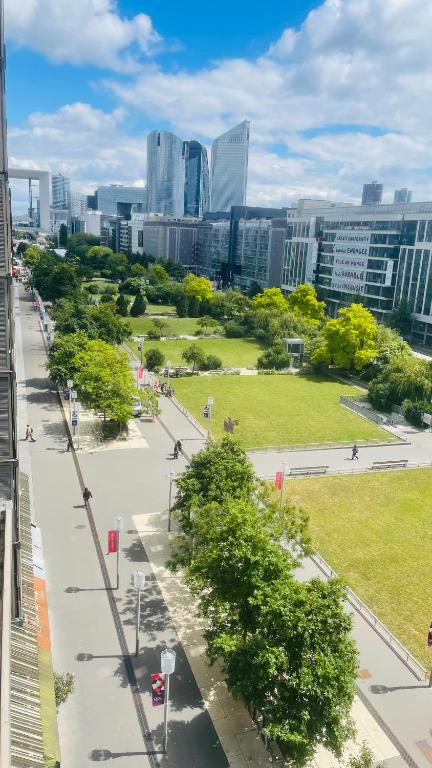 a view of a park in a city with tall buildings at Arena La defense nanterre préfecture- Une chambre in Nanterre