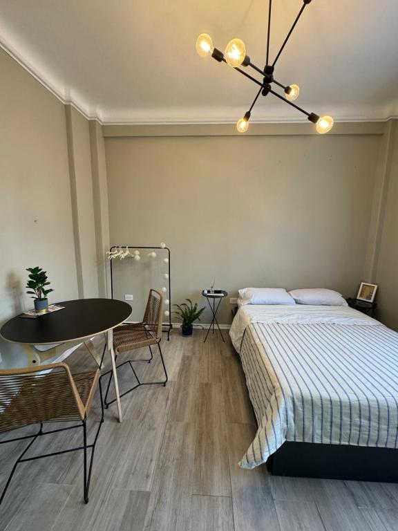 a bedroom with a bed and a table and a dining room at Hermoso Studio a metros del Obelisco in Buenos Aires