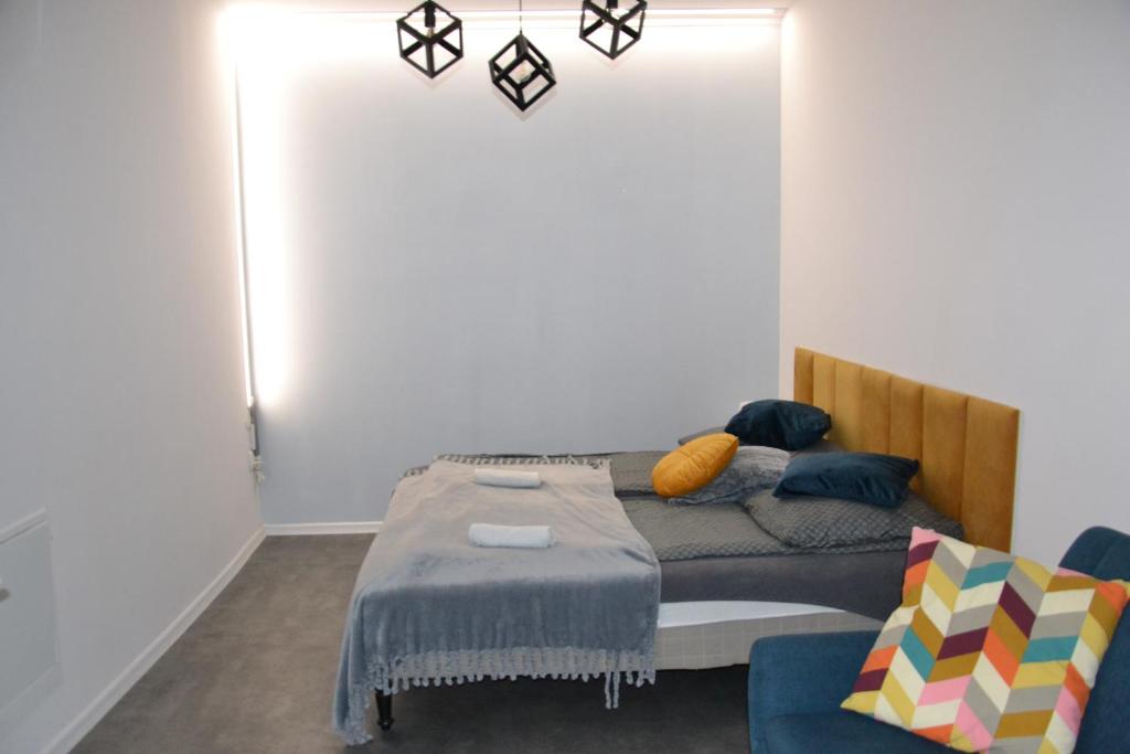 una camera da letto con un letto e un divano di Flores Apartament a Katowice