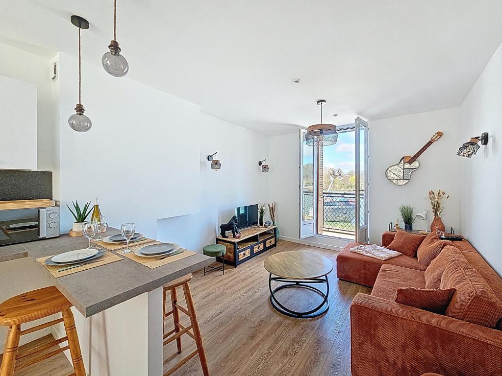 un salon avec un canapé et une table dans l'établissement Duplex lumineux et rénové - Vue Seine - Tout à pied, à Saint-Mammès